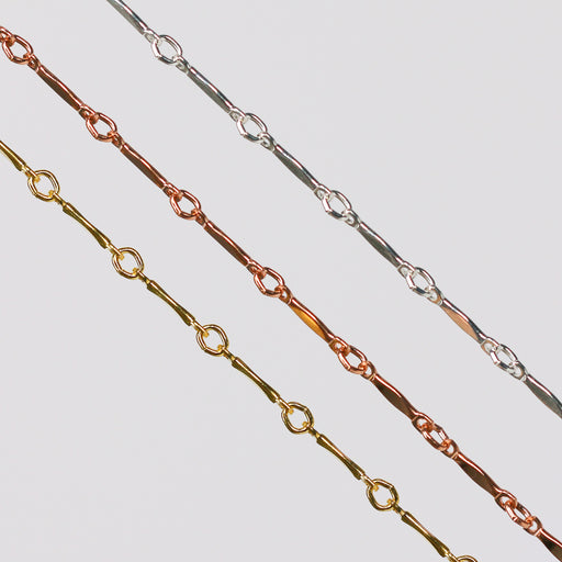Three dapped bar and link chains for permanent jewelry on a light gray background