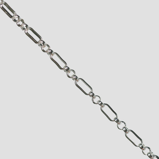 Silver rolo chain on a light gray background