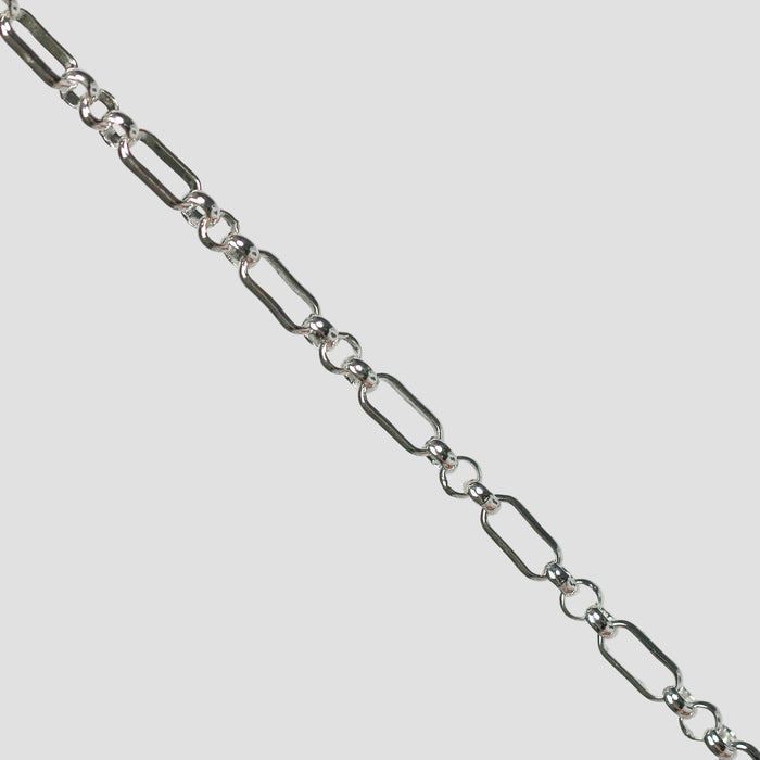 Silver rolo chain on a light gray background