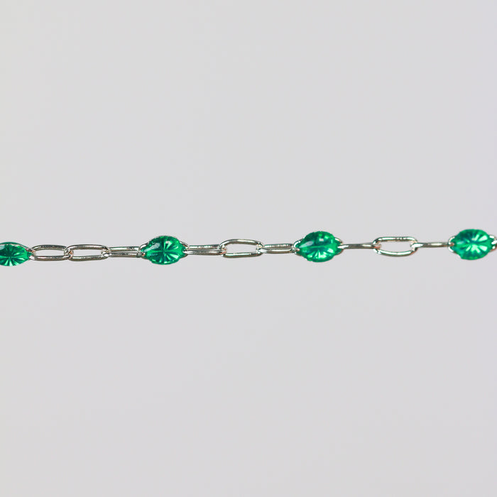 Sterling Silver (SS) cable chain with green enamel beads on it over a light gray background