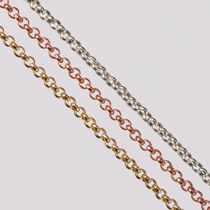 Three metal pj chains with rolo links. One in yellow gold, one in rose gold, and the last one in sterling silver.