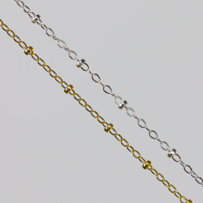 Two cable chains with beads on them. One chain is gold filled yellow and the other is sterling silver