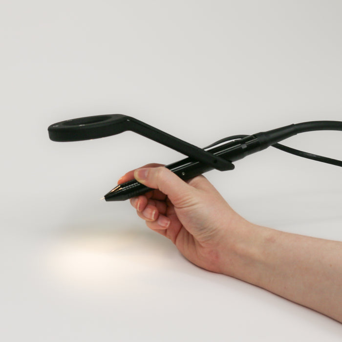 See the eclips being held on a stylus by a hand as the LED bright lights are shining down right to where permanent jewelry chain would be when welding.