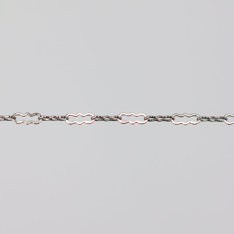 Solid white gold crinkled paperclip chain on a light gray background