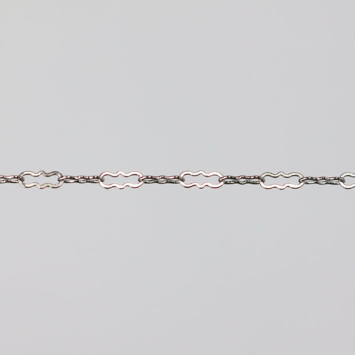 Solid white gold crinkled paperclip chain on a light gray background