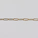 Yellow gold paperclip chain on a light gray background.