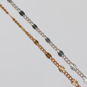 Two figaro chains with starburst links on a gray background.
