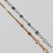 Two figaro chains with starburst links on a gray background.
