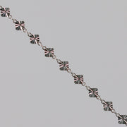 Silver chain with a reflective diamond disk on a gray background