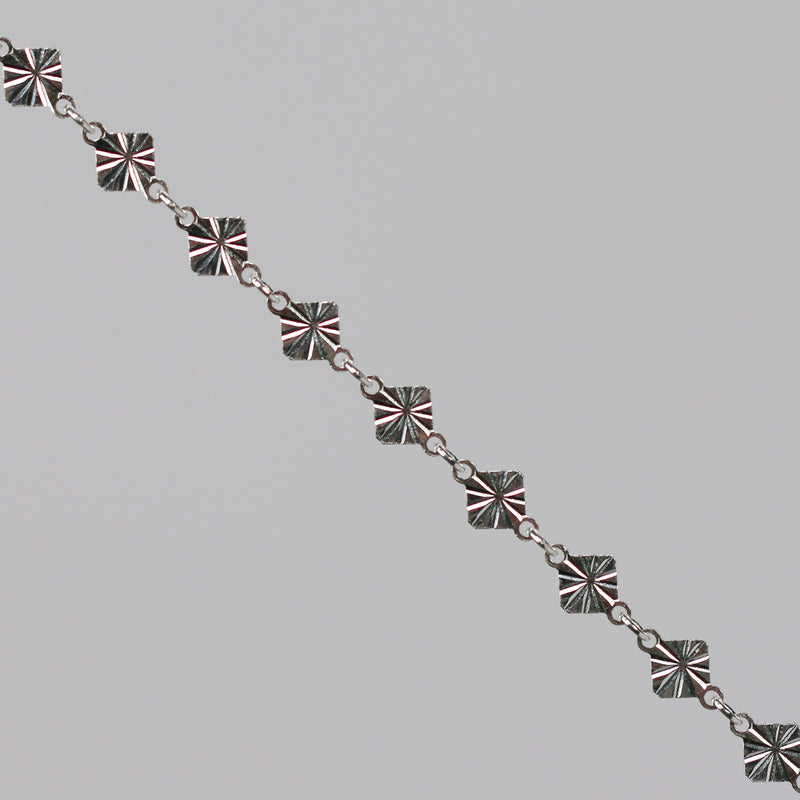 Silver chain with a reflective diamond disk on a gray background