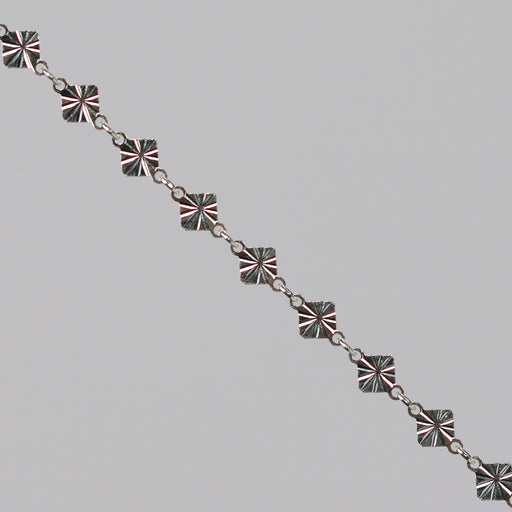 Silver chain with a reflective diamond disk on a gray background