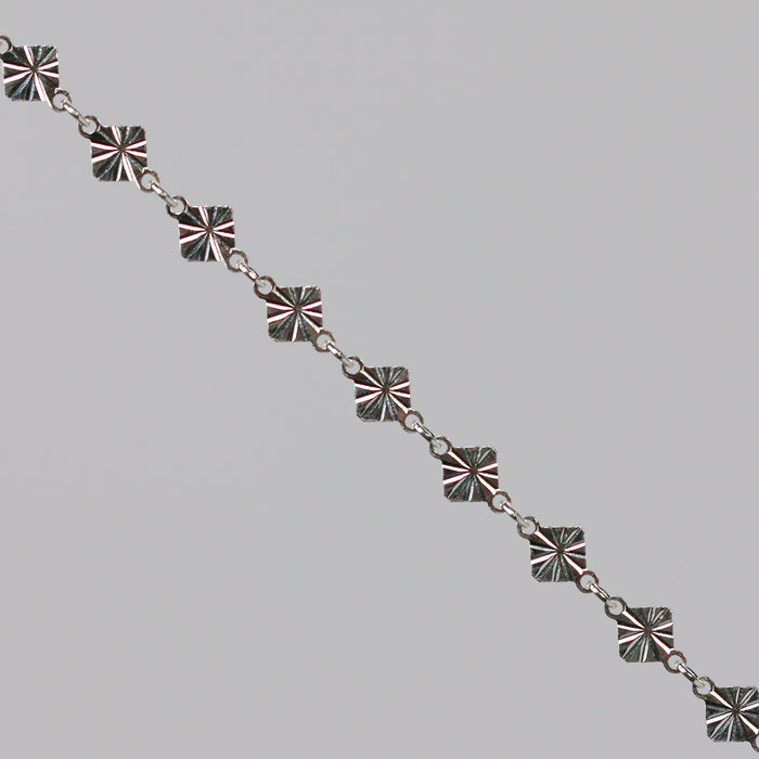 Silver chain with a reflective diamond disk on a gray background