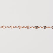 Zoomed in photo of the Brielle chain with shiny starburst links that catch the light on a plain background.