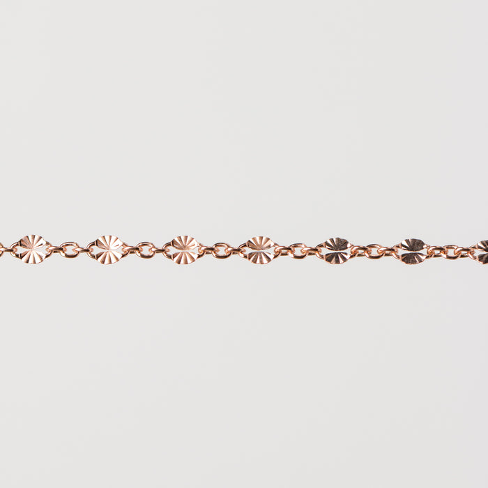 Zoomed in photo of the Brielle chain with shiny starburst links that catch the light on a plain background.