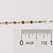 Photo of the Brielle chain in yelllow gold filled up against a ruler to help understand the size of the chain style.