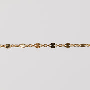 Zoomed in photo of a starburst shiny permanent jewelry chain in yellow gold filled.