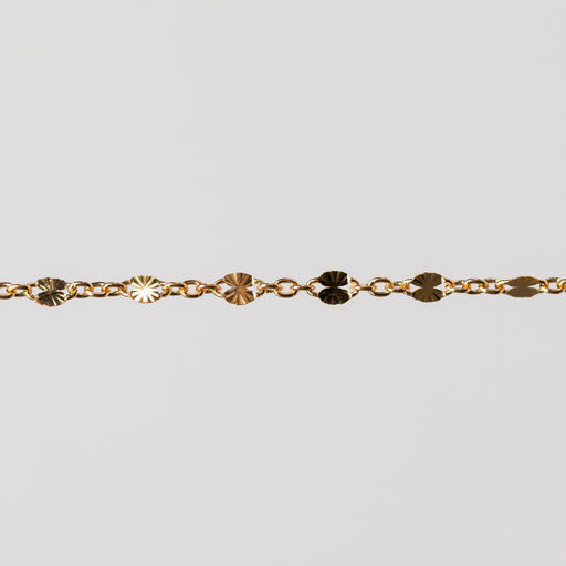 Zoomed in photo of a starburst shiny permanent jewelry chain in yellow gold filled.