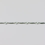 Silver dapped brittany chain close up on a light gray background.