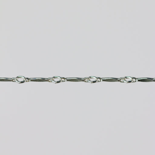 Silver dapped brittany chain close up on a light gray background.