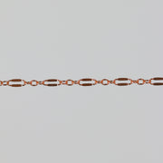 Closeup of the rose gold dapped bryce chain on a light gray background.