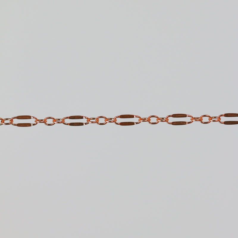 Closeup of the rose gold dapped bryce chain on a light gray background.