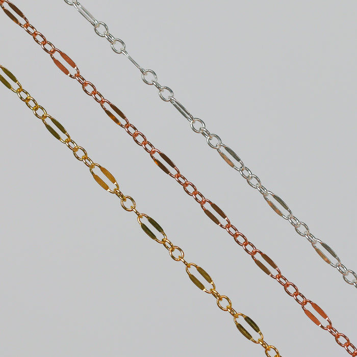 Three chains on a light gray background. The chains are Silver, Rose Gold, and Yellow Gold and have a long dapped link between three short links.