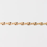 Gold chain bracelet closeup on a light gray background