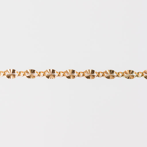 Gold chain bracelet closeup on a light gray background