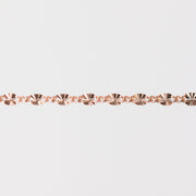 Rose gold chain bracelet closeup on a light gray background
