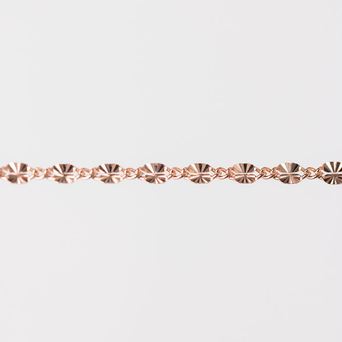 Rose gold chain bracelet closeup on a light gray background