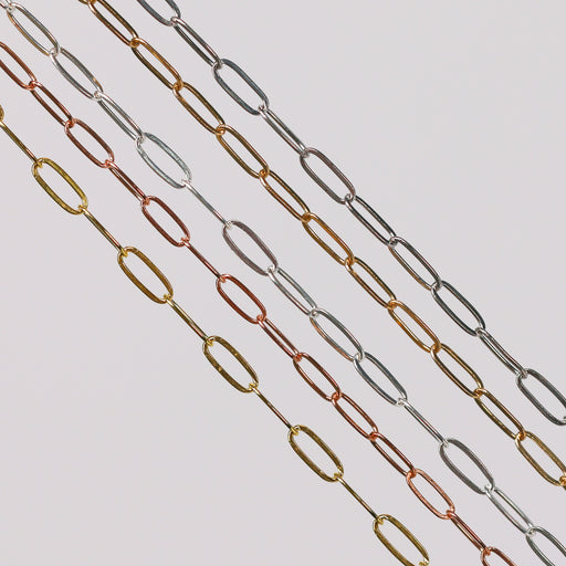 Flat elongated oval chains laid out side by side in different metal types. 14 karat gold, 14/20 gold filled, and sterling silver options are depicted.