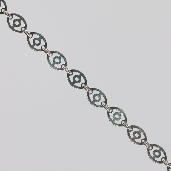Silver chain with disks linked together. The disks have holes in them that give the chain a light, airy look.