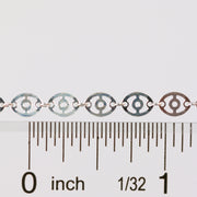 Silver chain against a ruler showing the size and dimension of the chain links and disks on the chain.