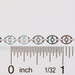 Silver chain against a ruler showing the size and dimension of the chain links and disks on the chain.
