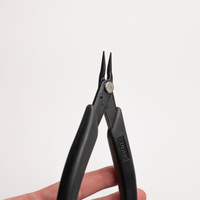 Black pliers held by a hand on a white background