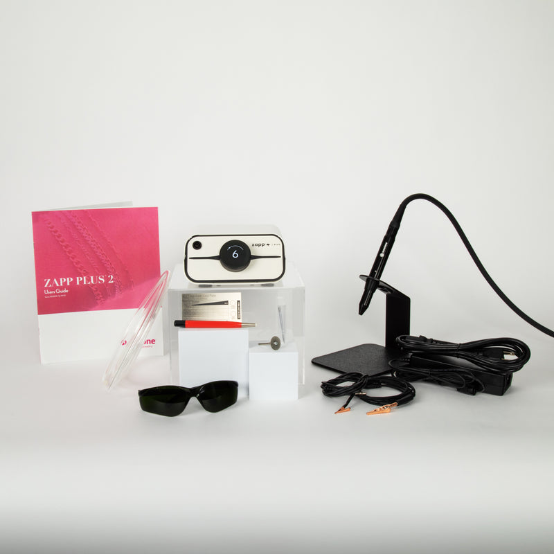 The Zapp Plus 2 PJ welder and the accessories that come with it that include the following: electrodes, user manual, argon gas tubing, a fiberglass brush, safety glasses, an electrode sharpening wheel, and grounding clips alongside the power supply and orion welding stylus.