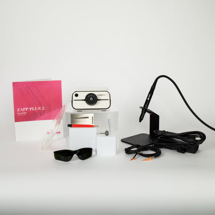 The Zapp Plus 2 PJ welder and the accessories that come with it that include the following: electrodes, user manual, argon gas tubing, a fiberglass brush, safety glasses, an electrode sharpening wheel, and grounding clips alongside the power supply and orion welding stylus.