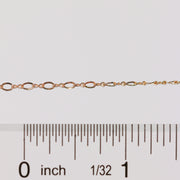 Gold chain with a ruler for scale on a white background