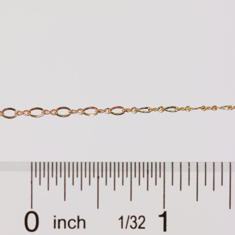 Gold chain with a ruler for scale on a white background
