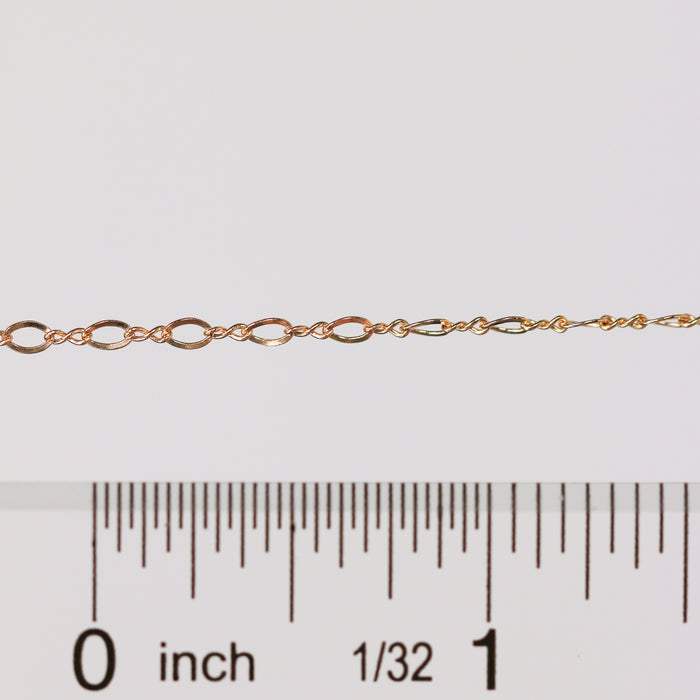 Gold chain with a ruler for scale on a white background