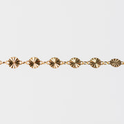 Gold bracelet with circular hammered links on a white background