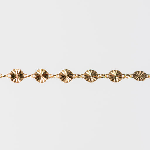 Gold bracelet with circular hammered links on a white background