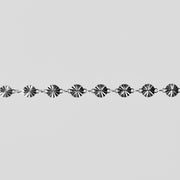 Silver chain with decorative links on a light gray background
