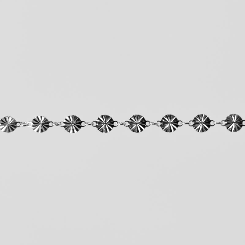 Silver chain with decorative links on a light gray background