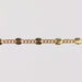 Gold chain bracelet on gray background showing the starburst design up close.