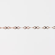 Rose gold infinity chain bracelet on a light gray background