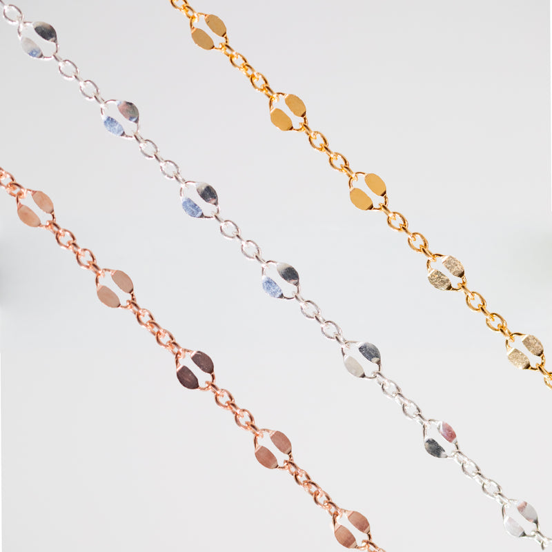 Three delicate chain bracelets in yellow gold, silver, and rose gold, each featuring a row of alternating small round and large hammered links, displayed against a clean white background.