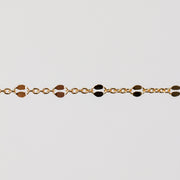 Gold bracelet with hammered links on a light gray background
