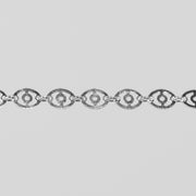Closeup shot of the claire silver chain with disks linked together over a light gray background