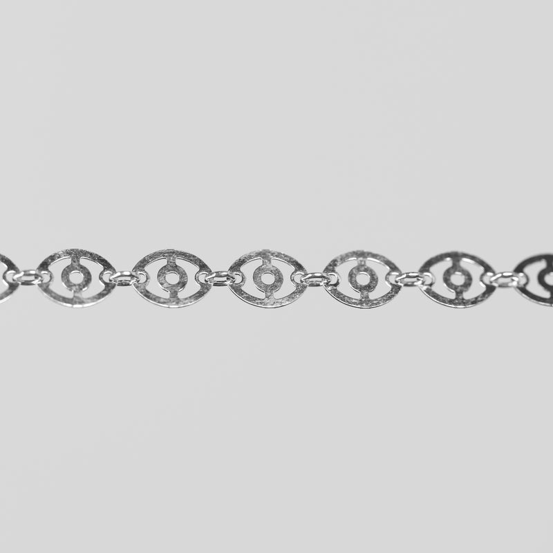 Closeup shot of the claire silver chain with disks linked together over a light gray background